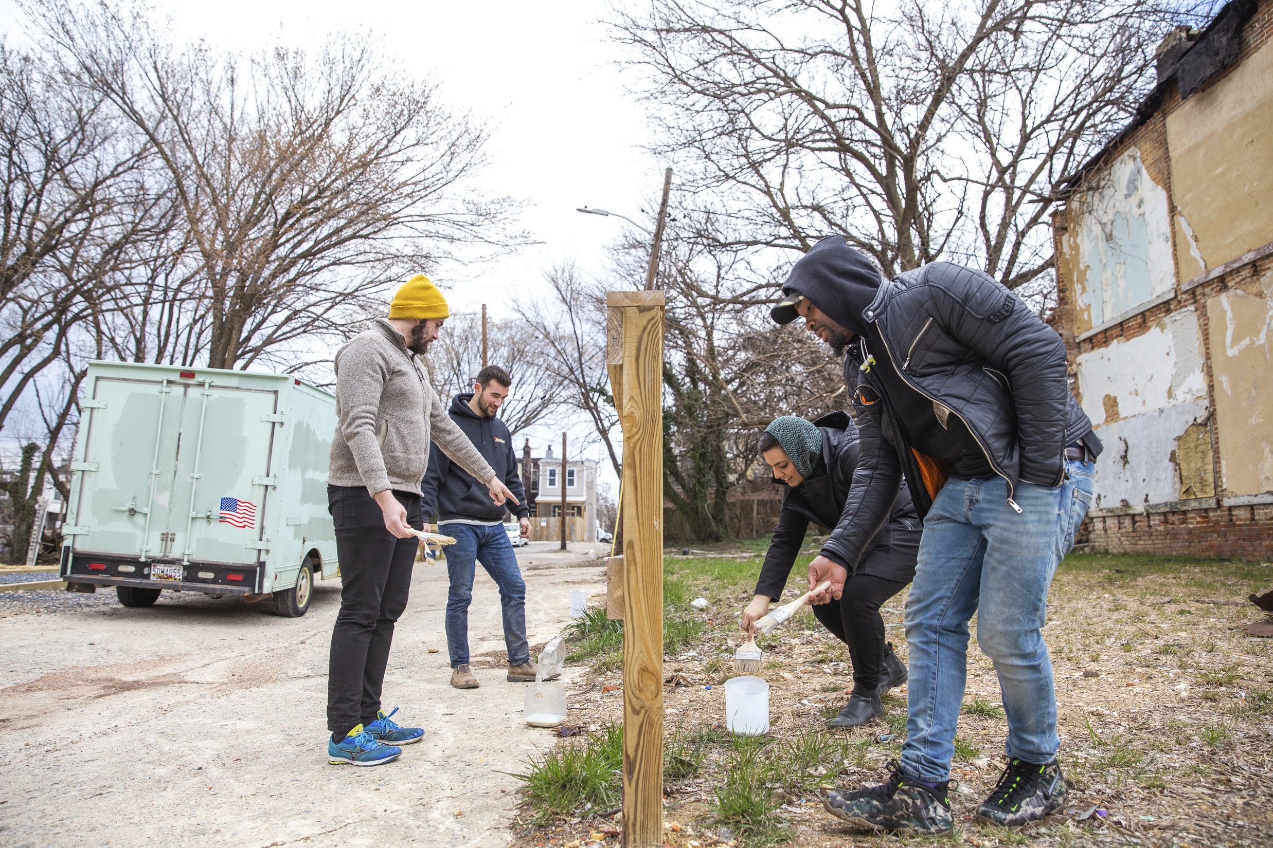 People working together to paint a fence at Kirby Lane Park during the Jim Wheeler Day of Service