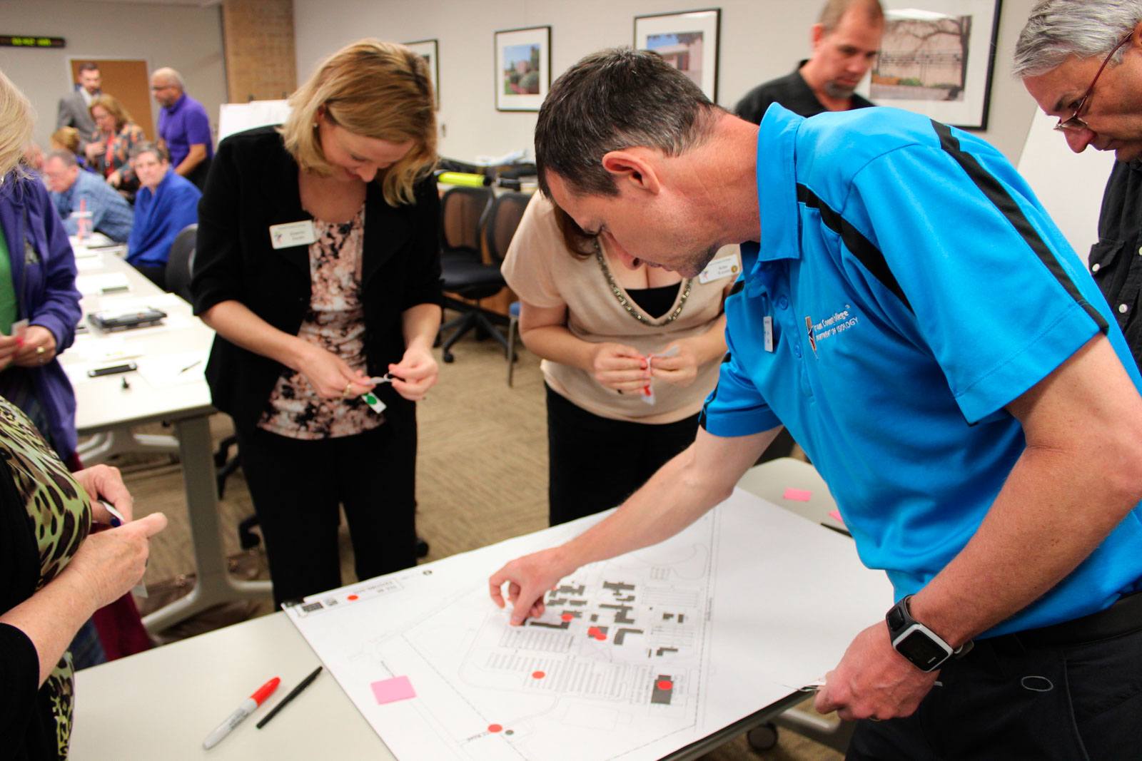 Charette participants place dots during an engagement exercise for Tarrant County College