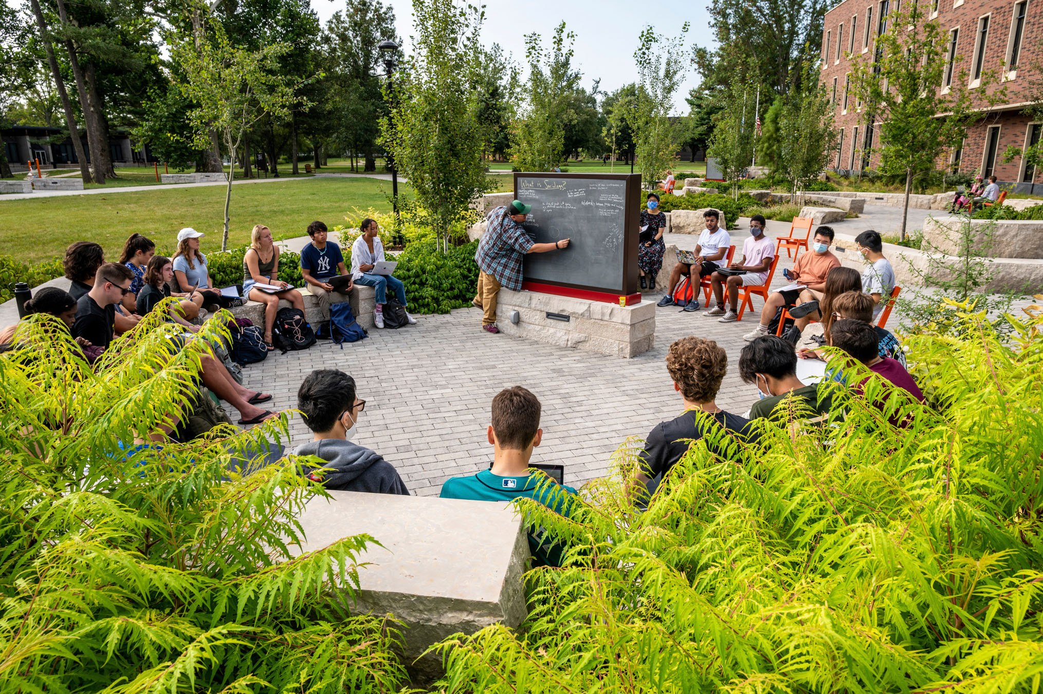 Jules Bacon, Visiting Assistant Professor of Sociology teaches class outside at Grinnell College.
