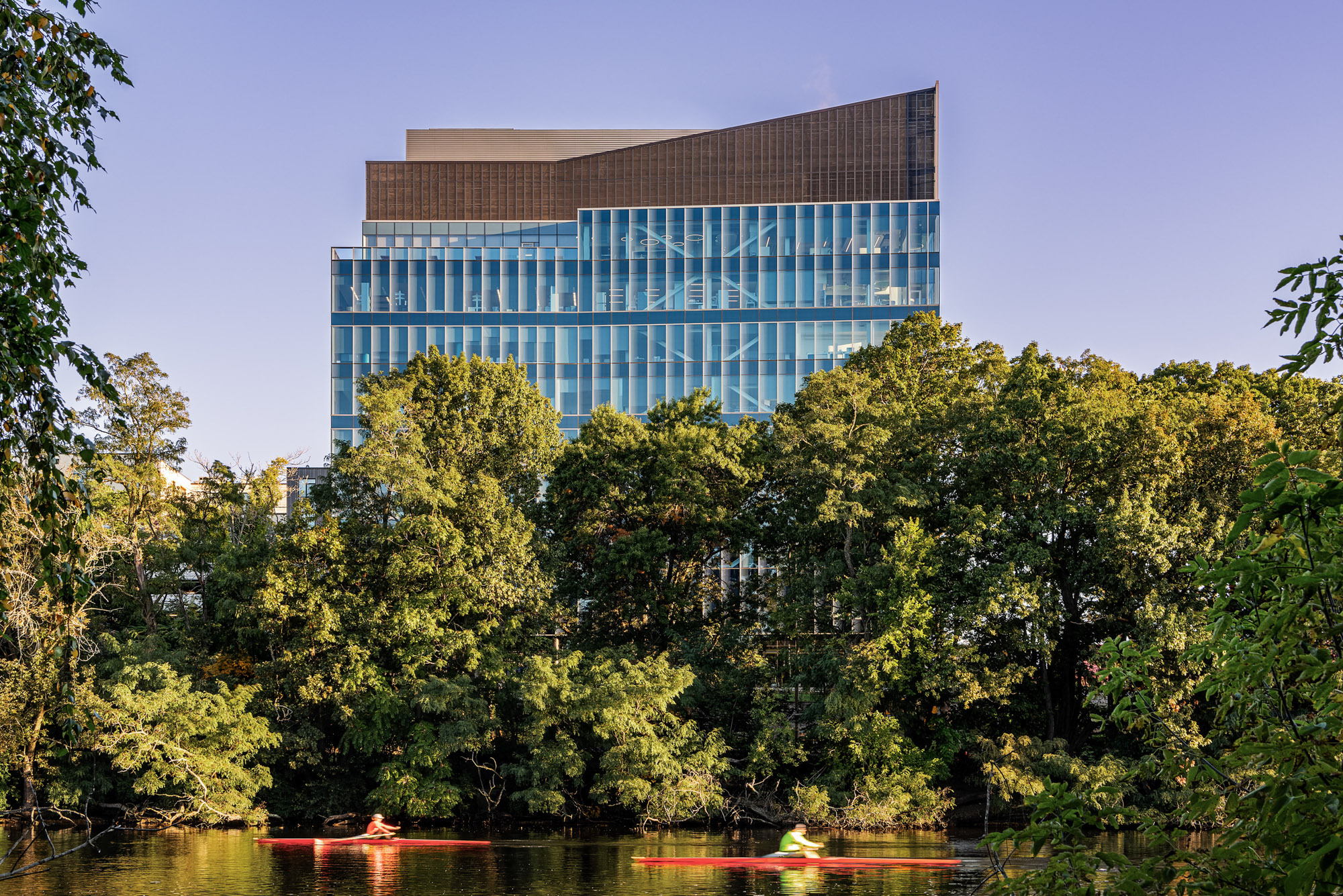 A view of the 100 Forge roof, as seen over a park by the Charles River