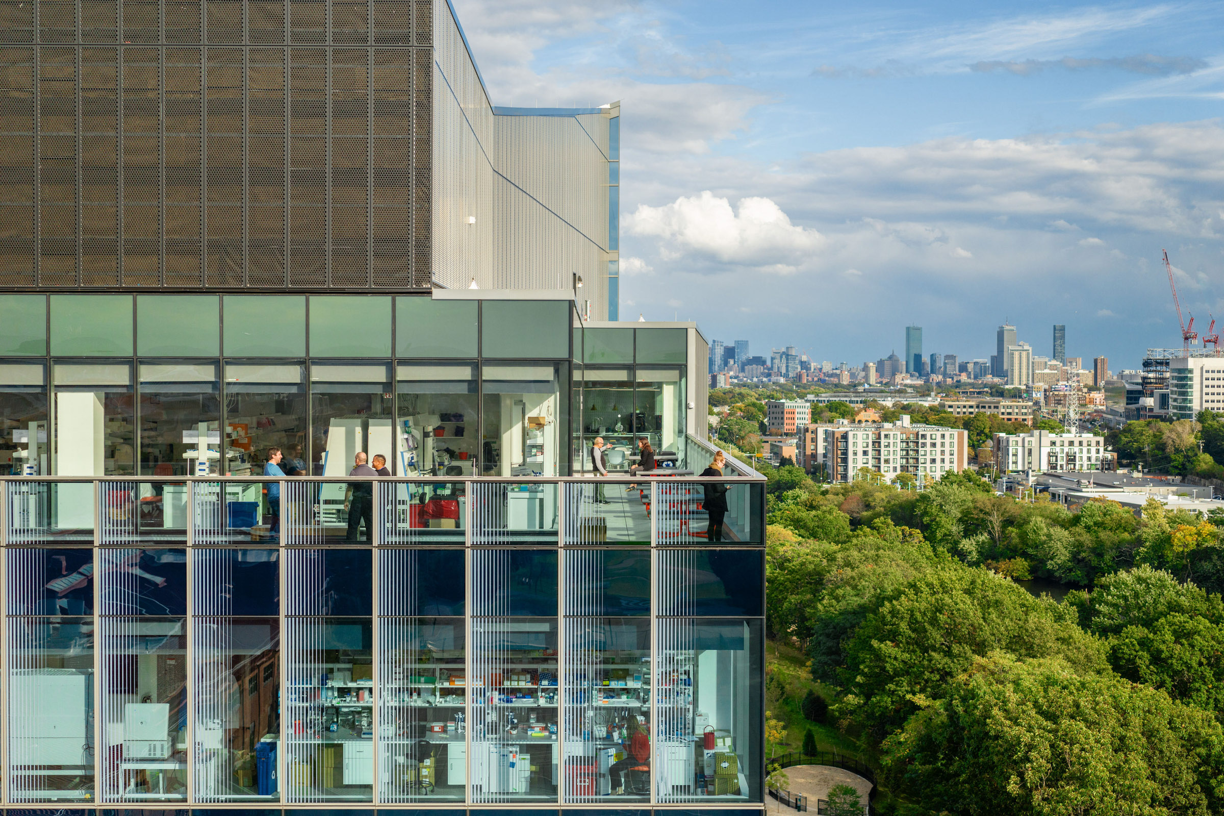 People gather on the 100 Forge Terrace, with views into Boston seen in the background.