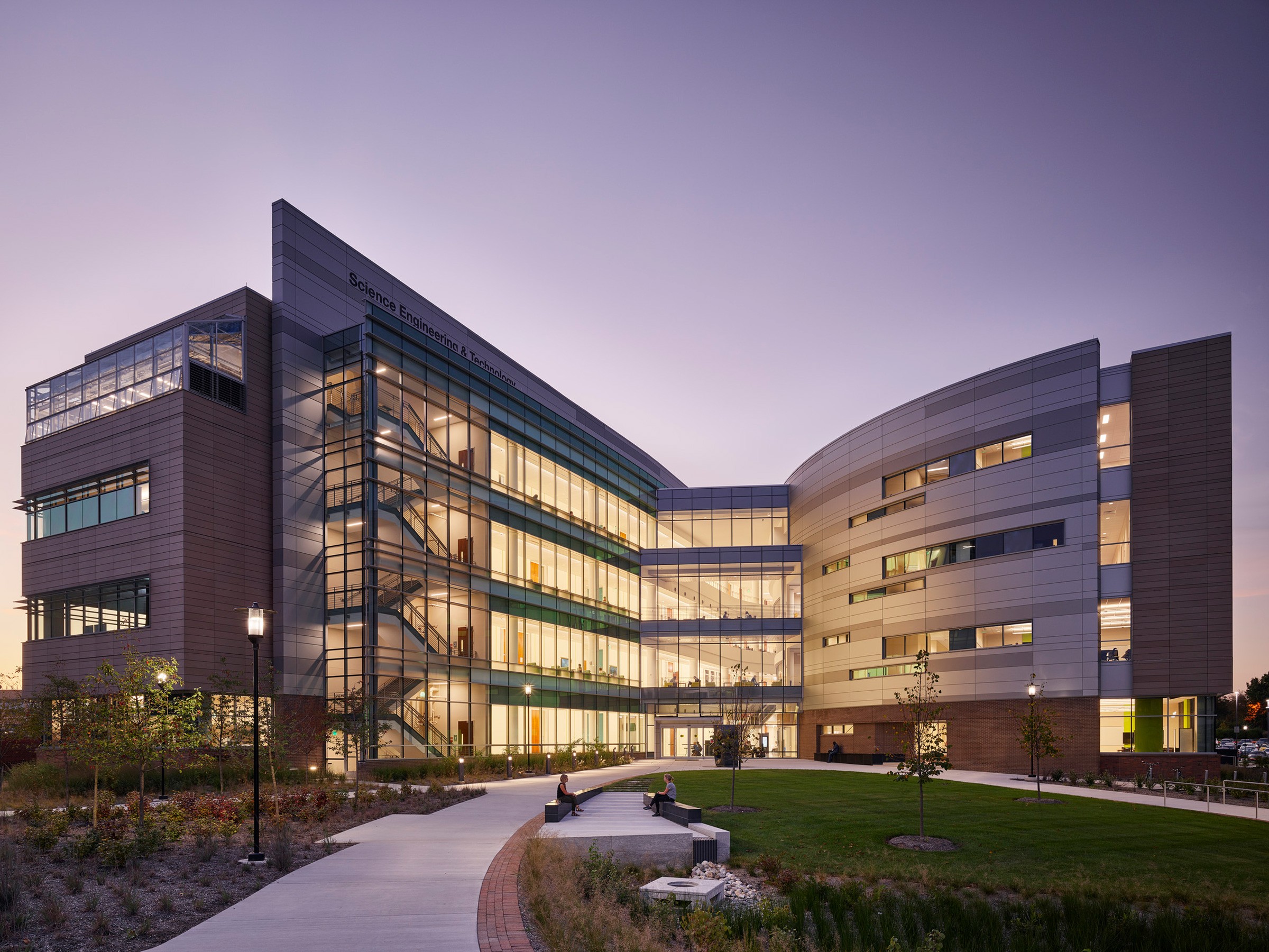The building’s campus-facing façade illuminated at dusk.
