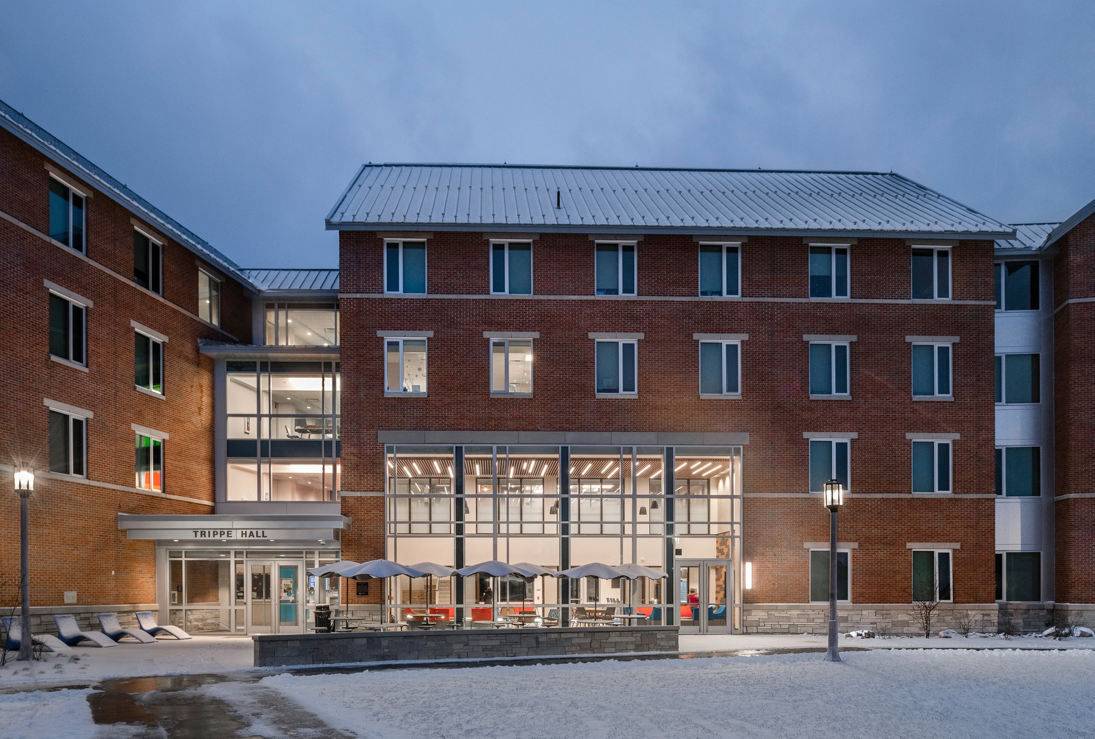 Exterior view of the glass and brick main façade of Trippe Hall at Penn State Behrend on a snowy...