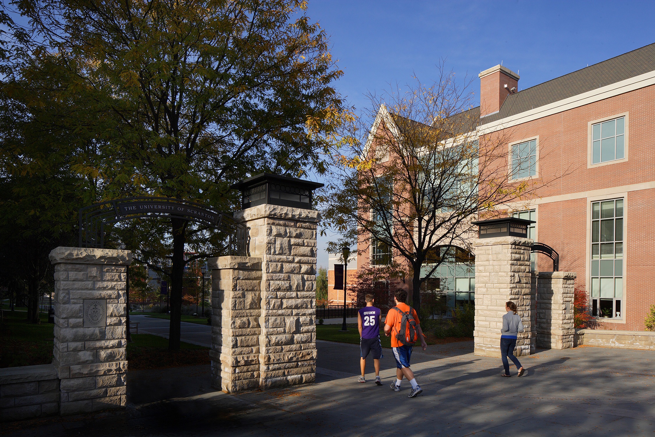 Image of people passing through a new stone gateway that was implemented as part of the University...