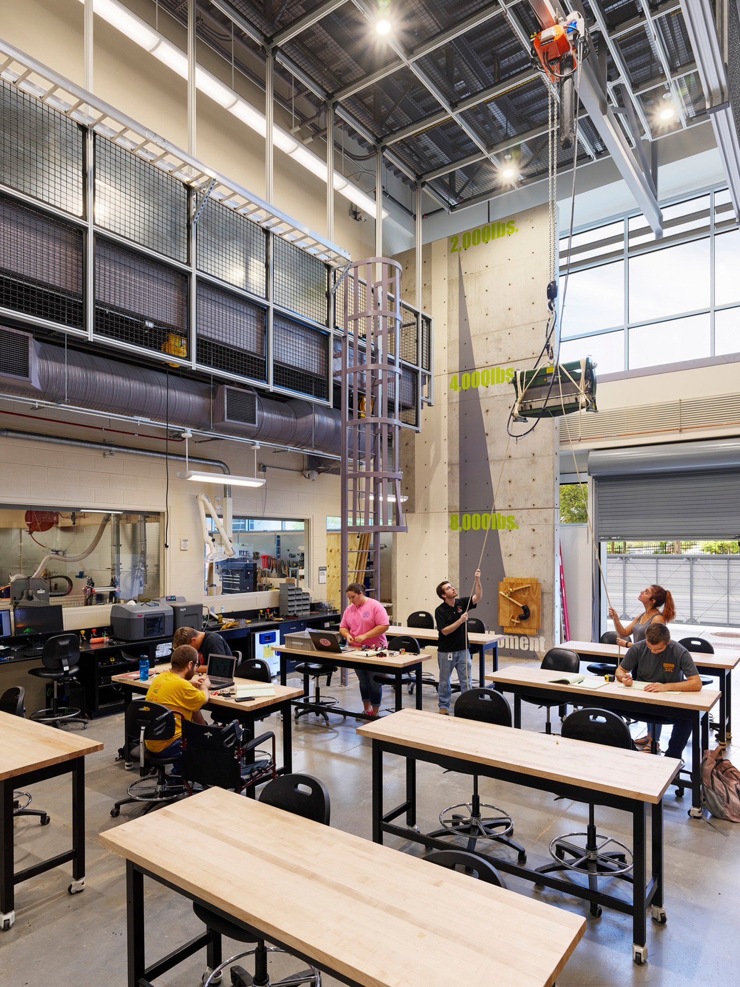 A classroom with students utilizing tools such as a moveable ceiling crane and a three-dimensional...