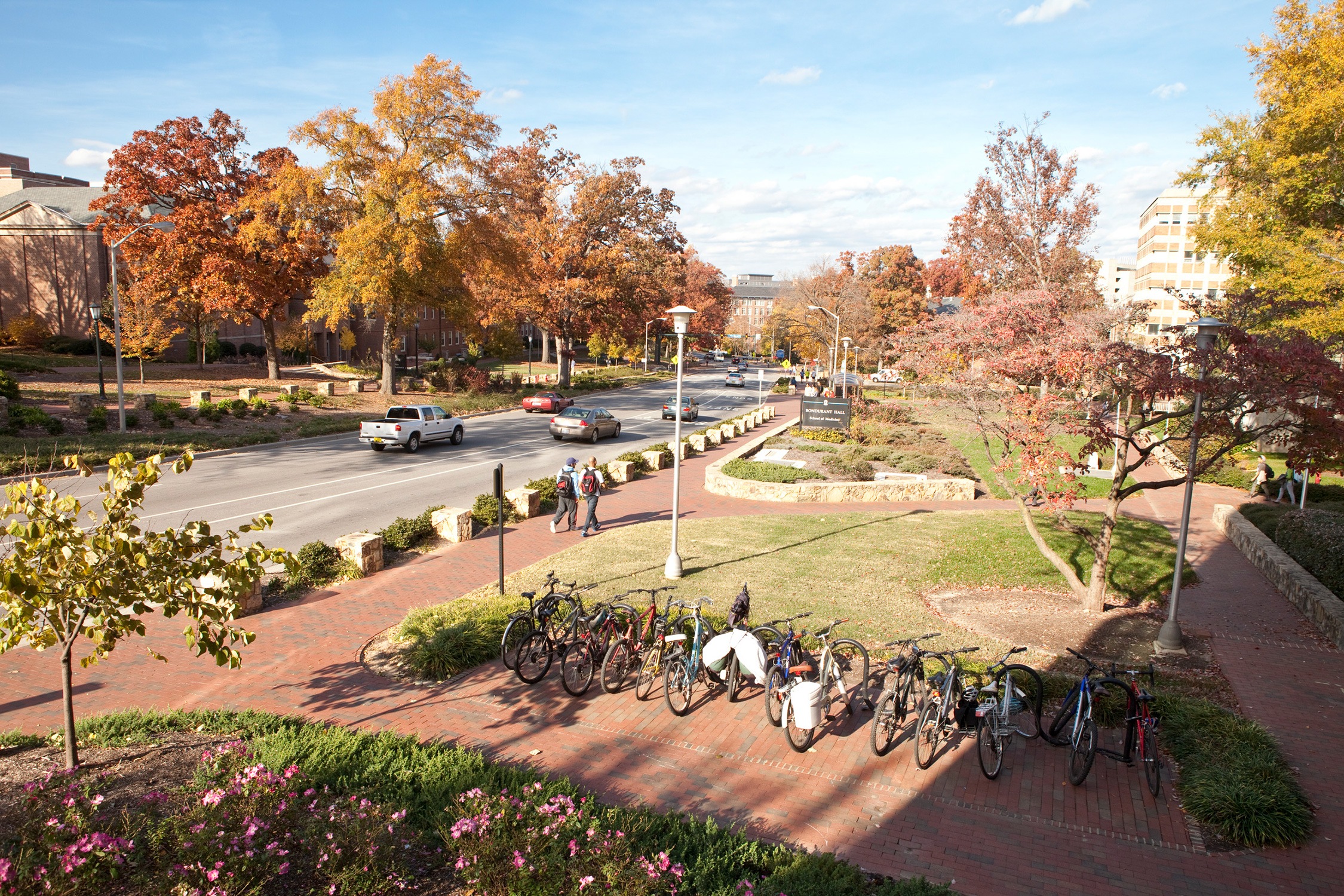 Walkways and low stone walls along a heavily trafficked campus street.