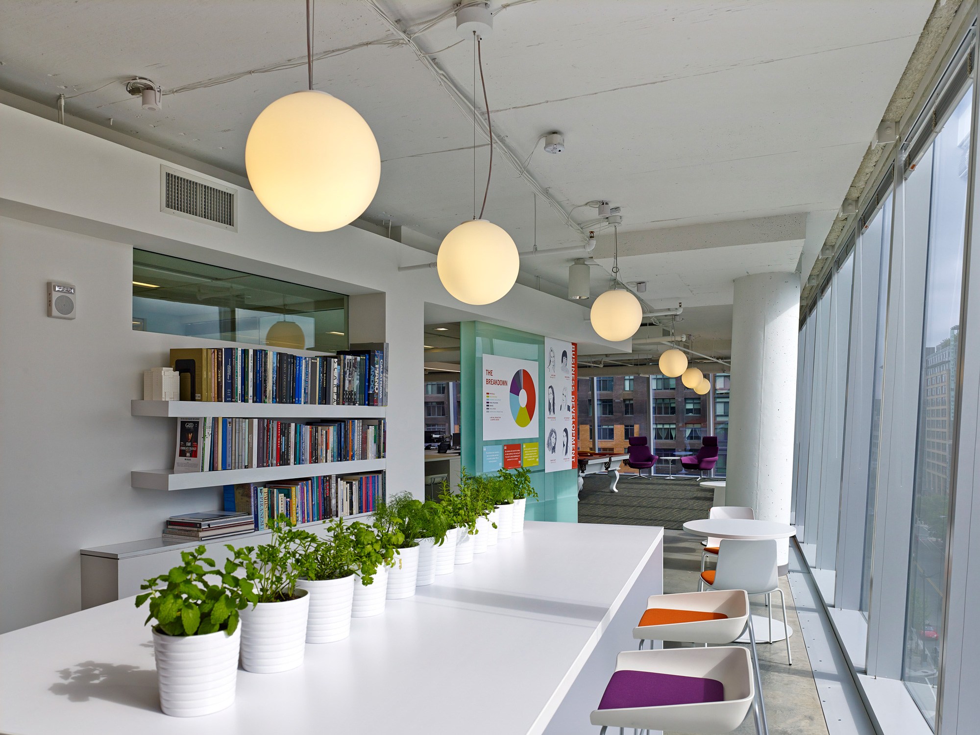 Interior of the Ayers Saint Gross DC office, the sunlit café’s white communal high-top table and...