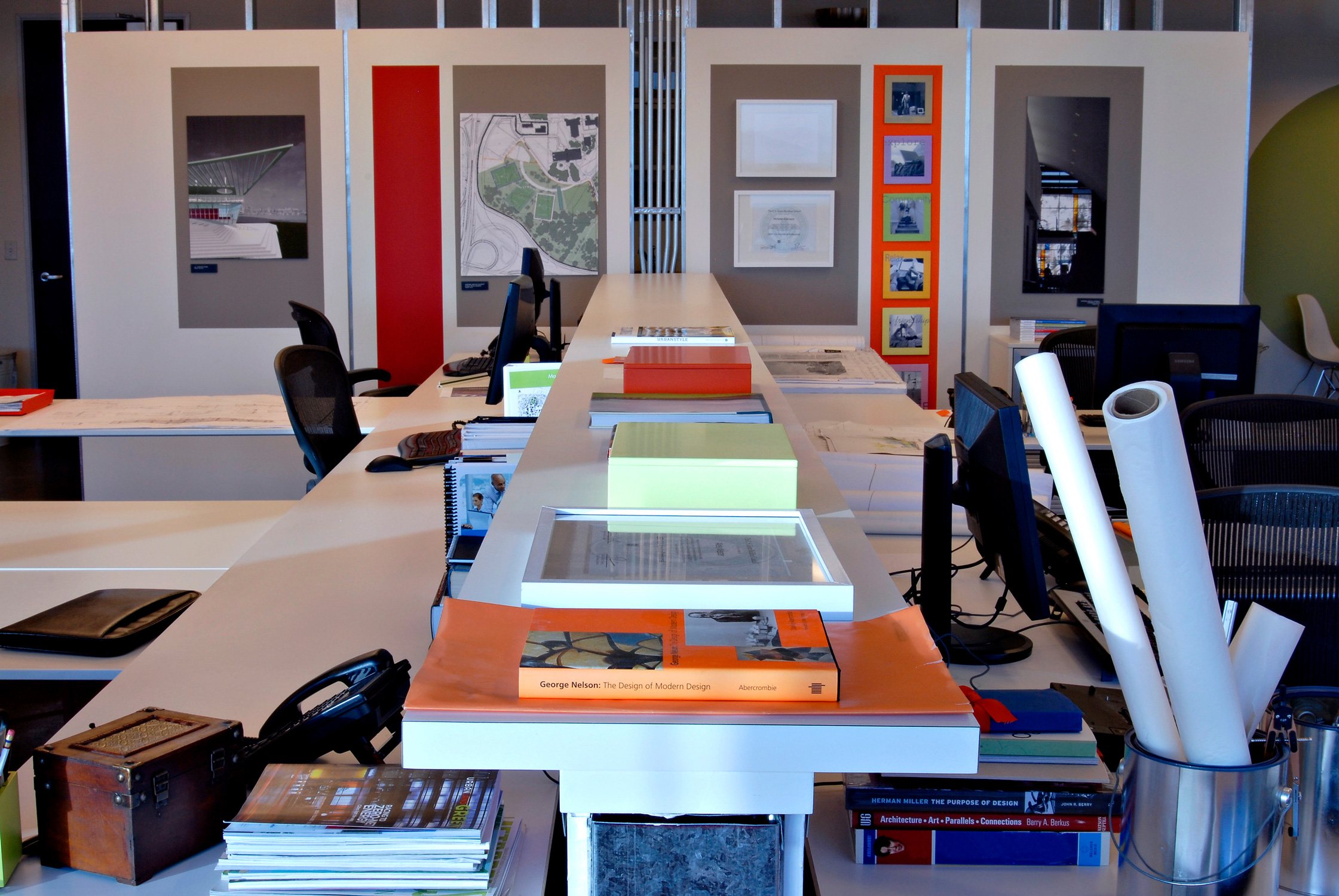 Ayers Saint Gross Tempe office workspaces with computers and books in the foreground looking at...