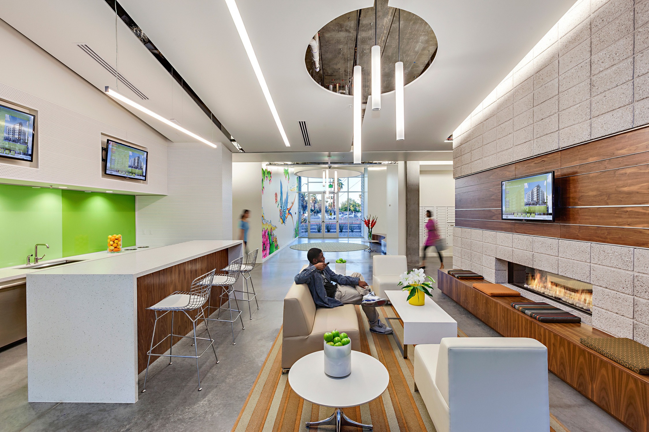 Roosevelt Point lounge featuring modern furniture and pendant lights, a gas fireplace, and a common...