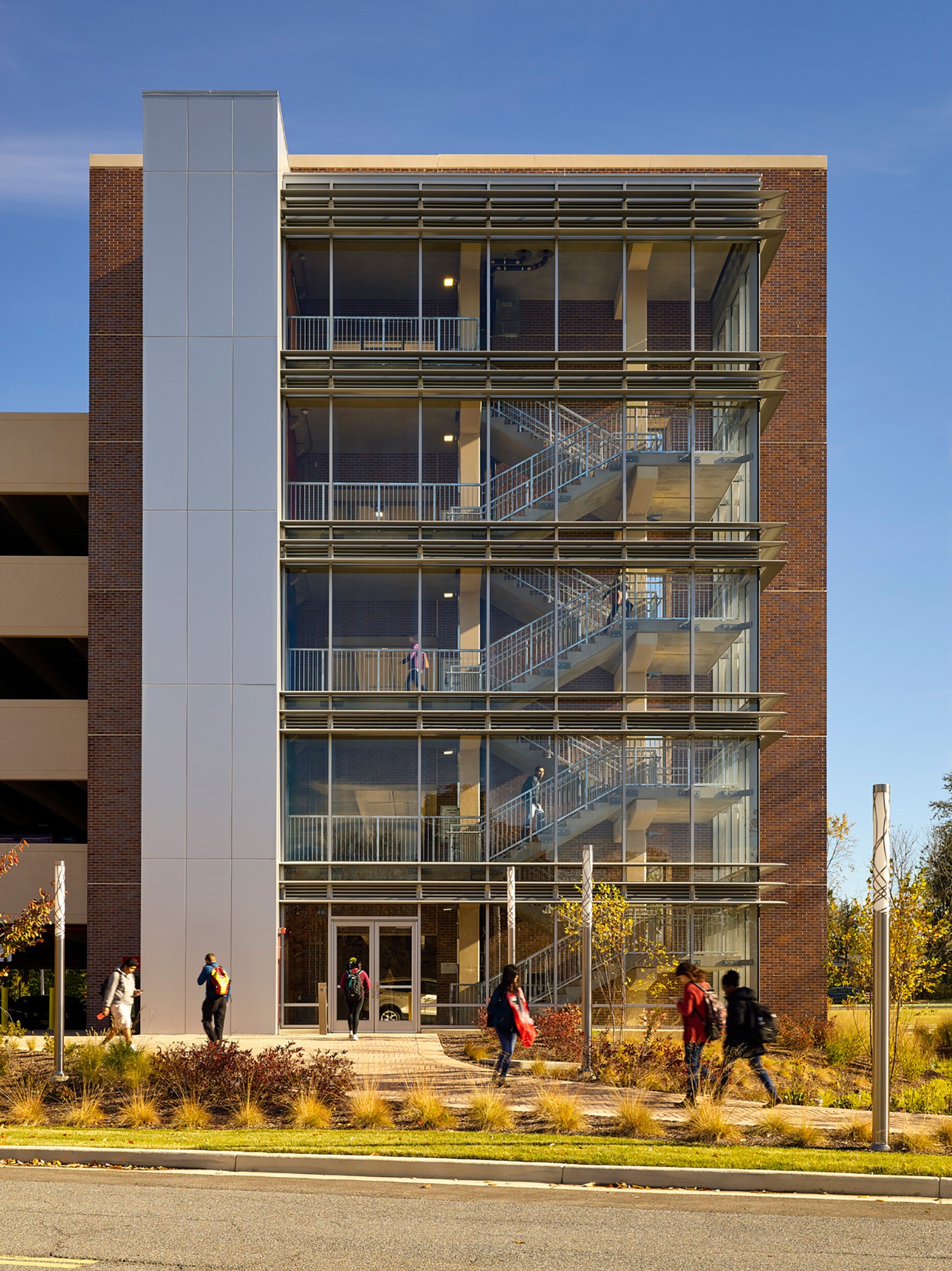 Well-lit safe staircase with landscape in the foreground at Universities at Shady Grove garage