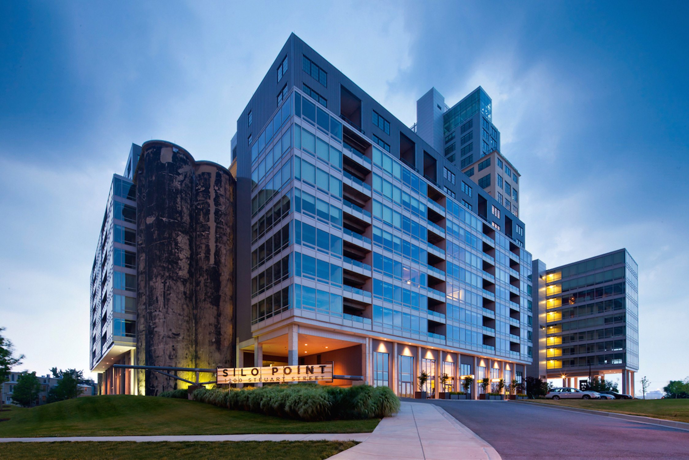 Illuminated signage at the top of Silo Point from the harbor at dusk