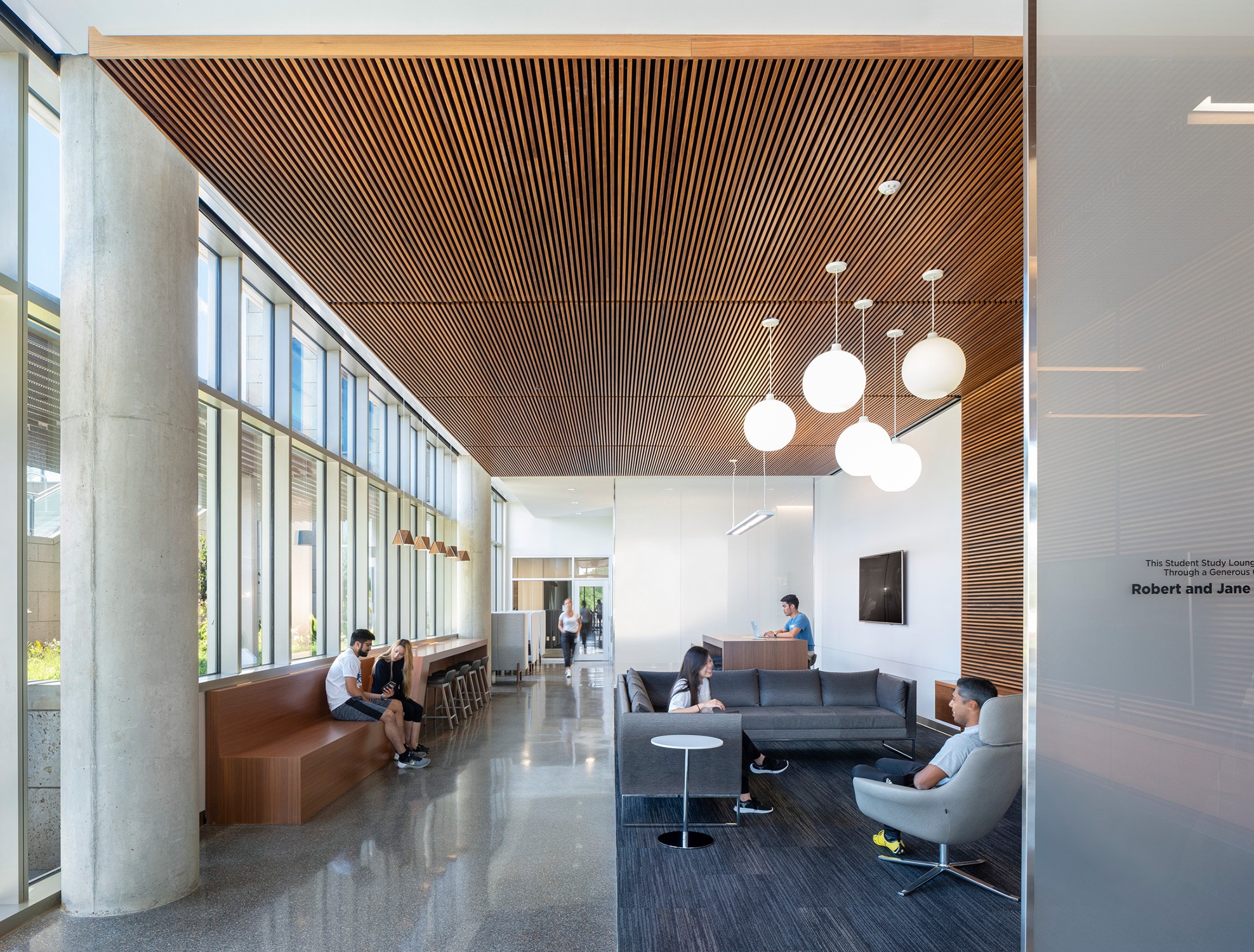 Interior collaboration spaces with wood paneled ceilings and lots of natural light at the University...