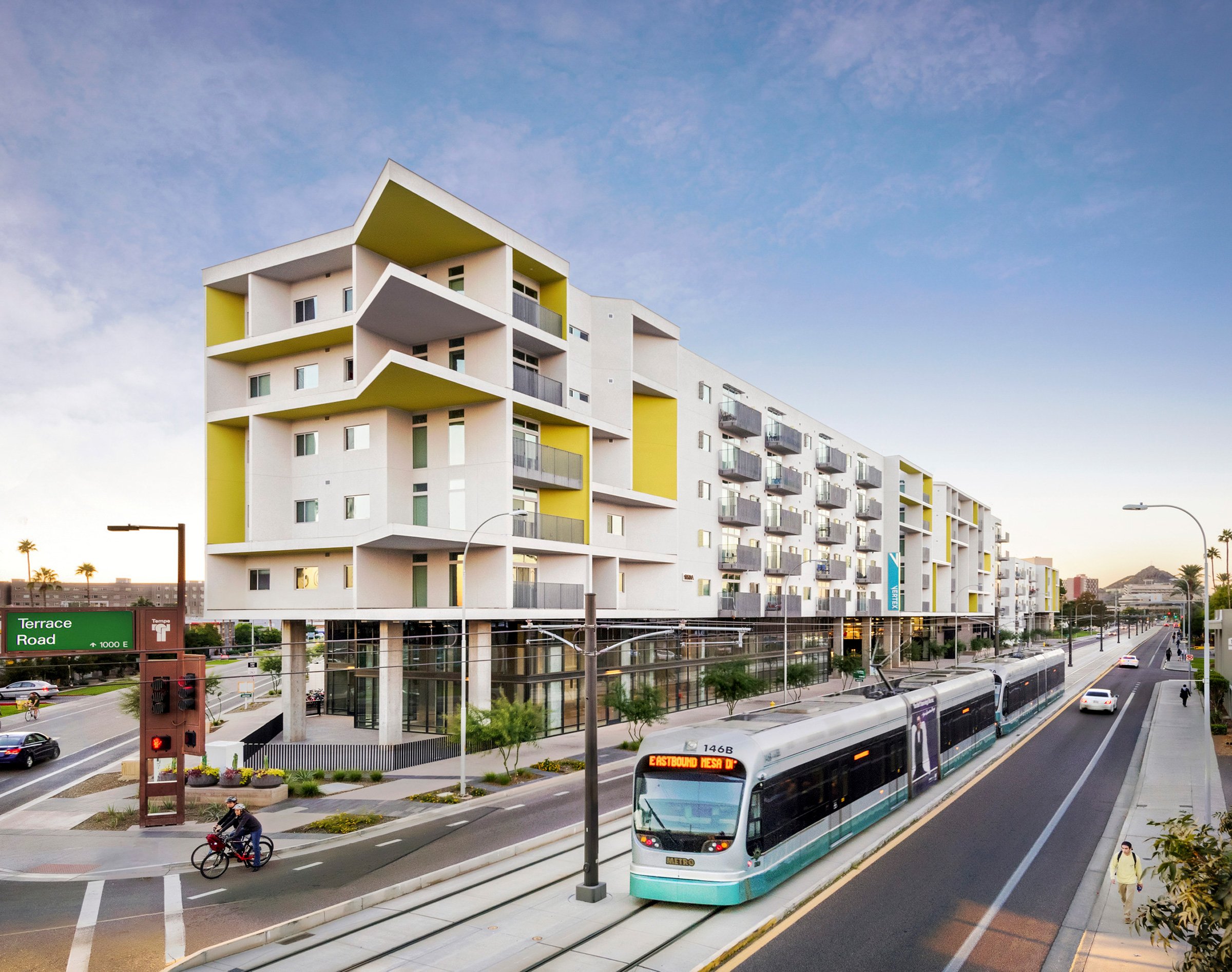 Exterior of Peak Campus' Vertex Student Apartments with transit in the foreground