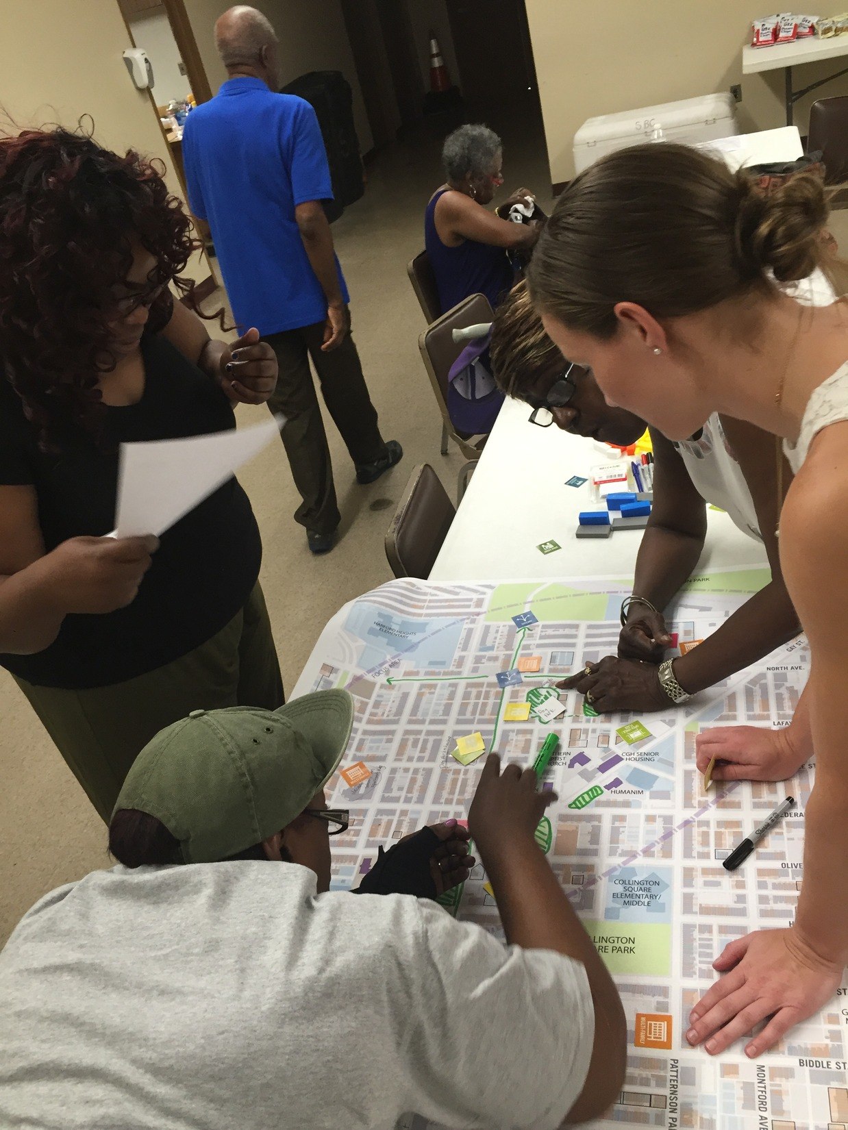 Participants stand over a map as part of the East Baltimore Revitalization Plan