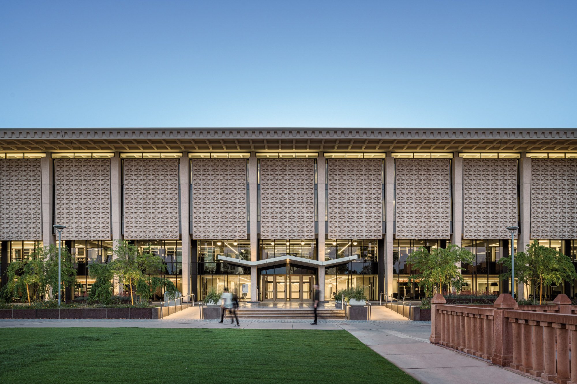 Exterior view of west elevation at dawn looking into the west lobby and second floor collections at the Arizona State University Hayden Library Reinvention.