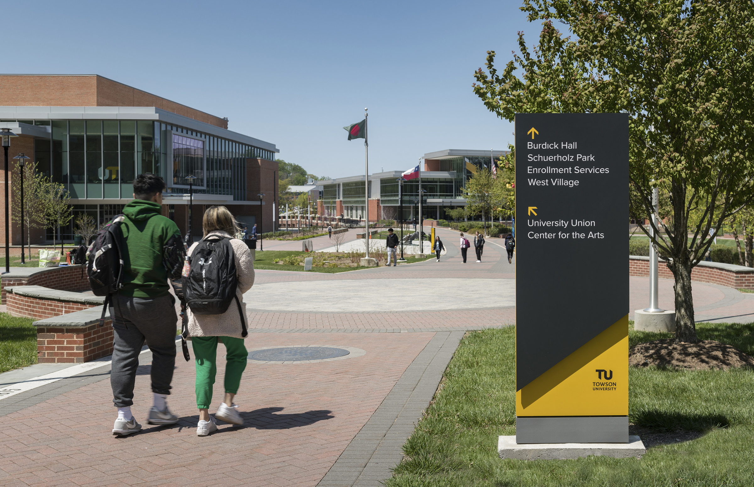 Towson students walk by a new navigational sign designed by Ayers Saint Gross.