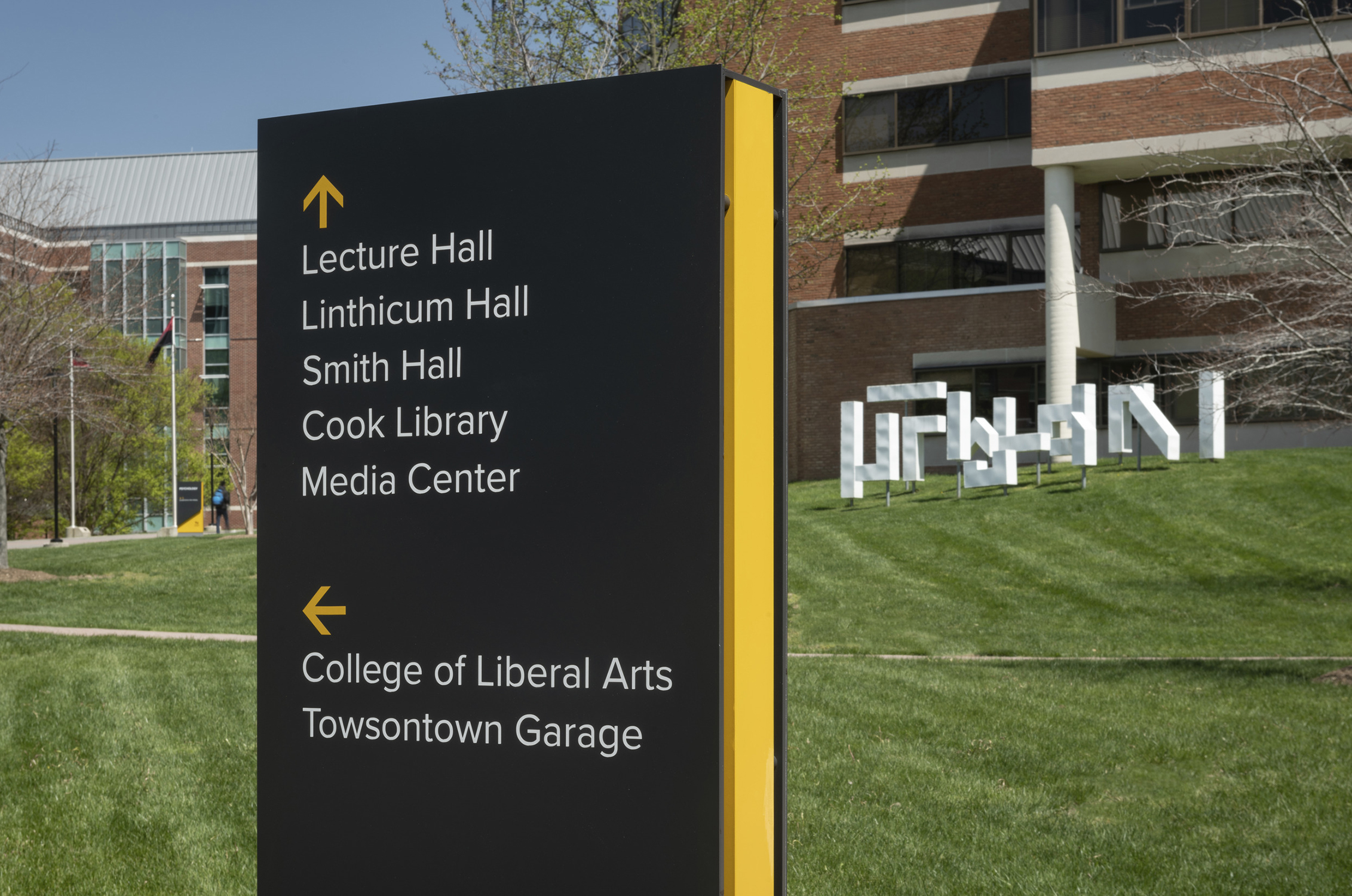 A custom sign at Towson University features clear wayfinding instruction and reinforces University...