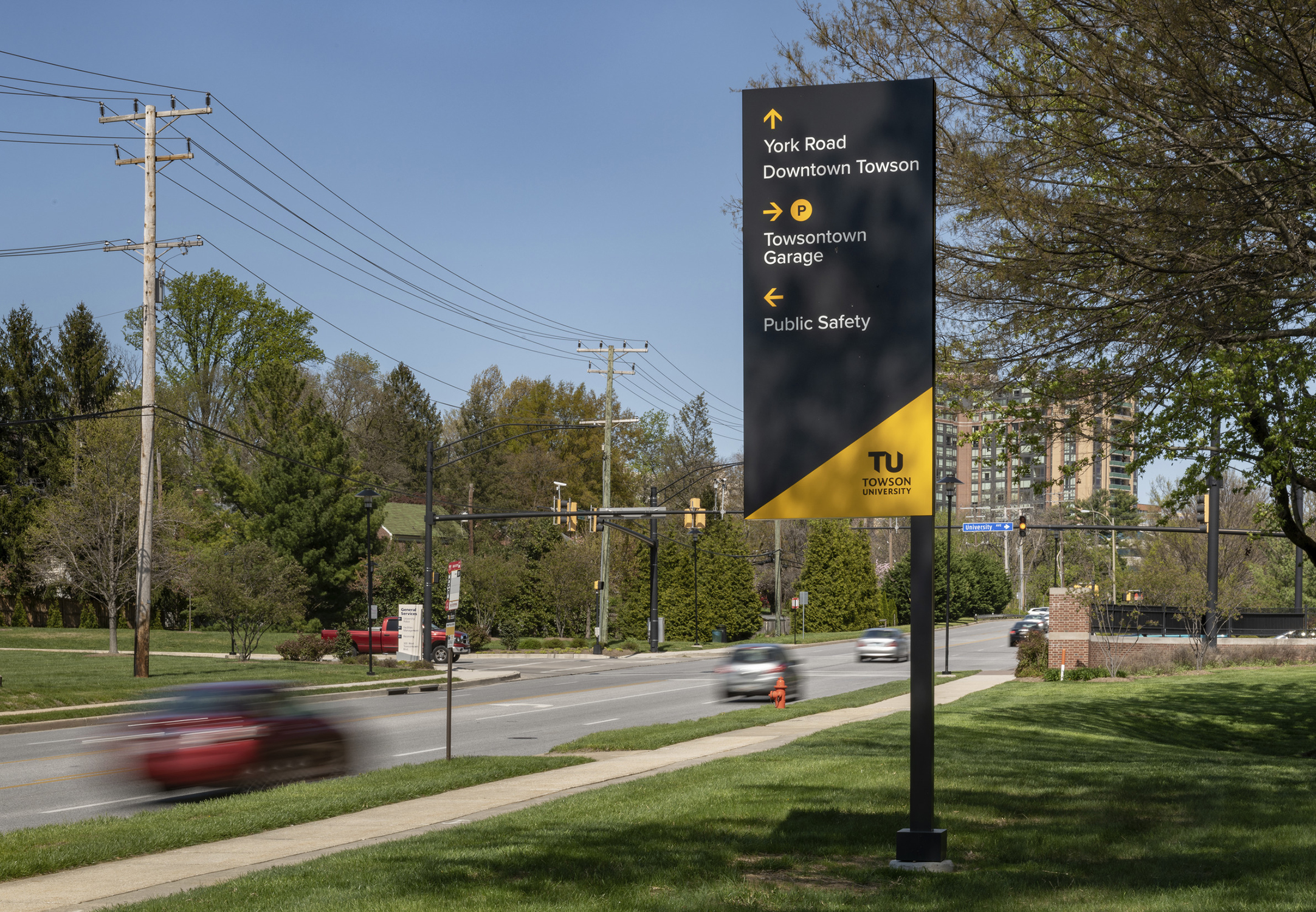 Towson University signage provides navigational and parking directions for drivers.