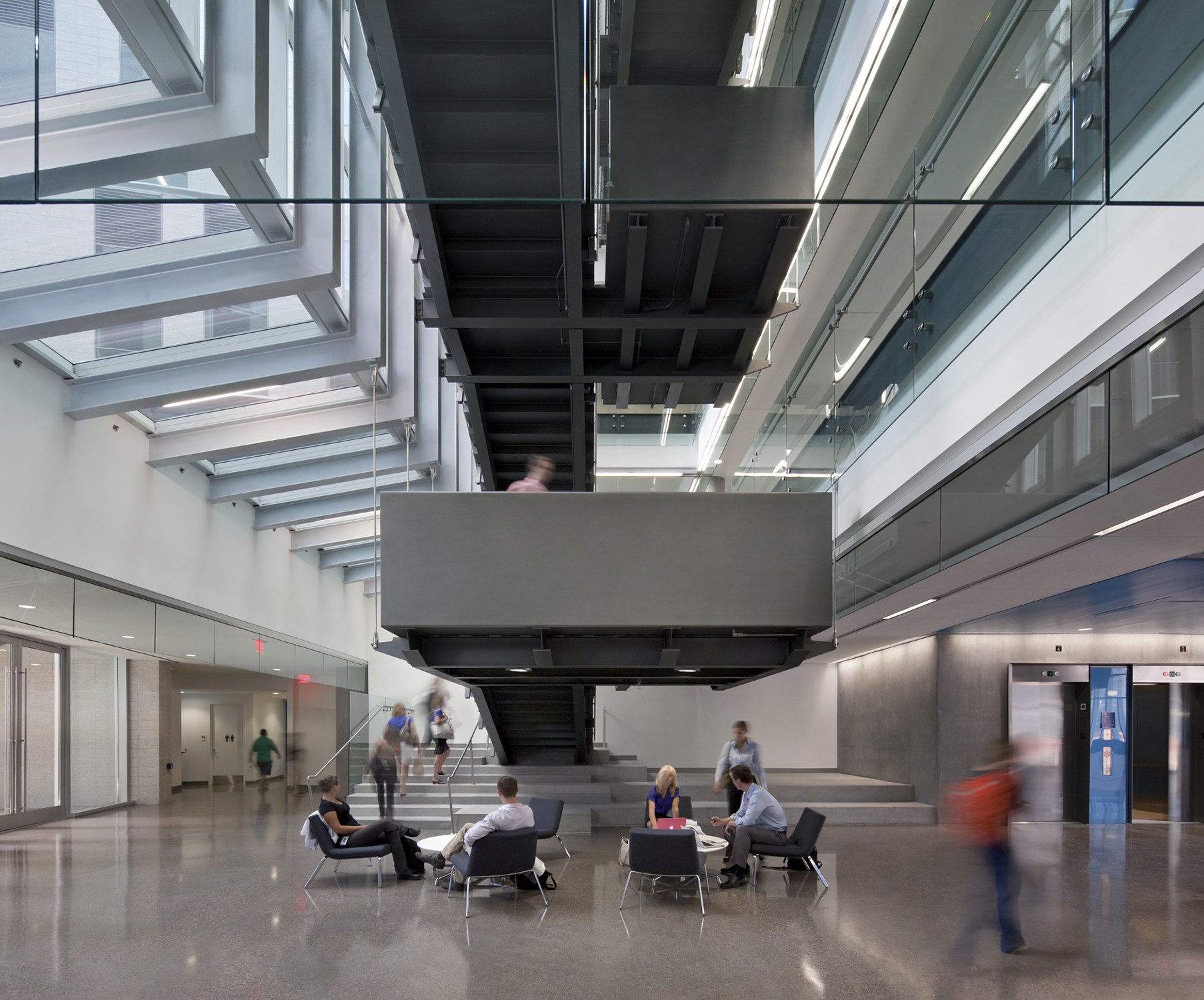 Interior shot of a lobby and collaboration space with floating concrete open stairs at the University...