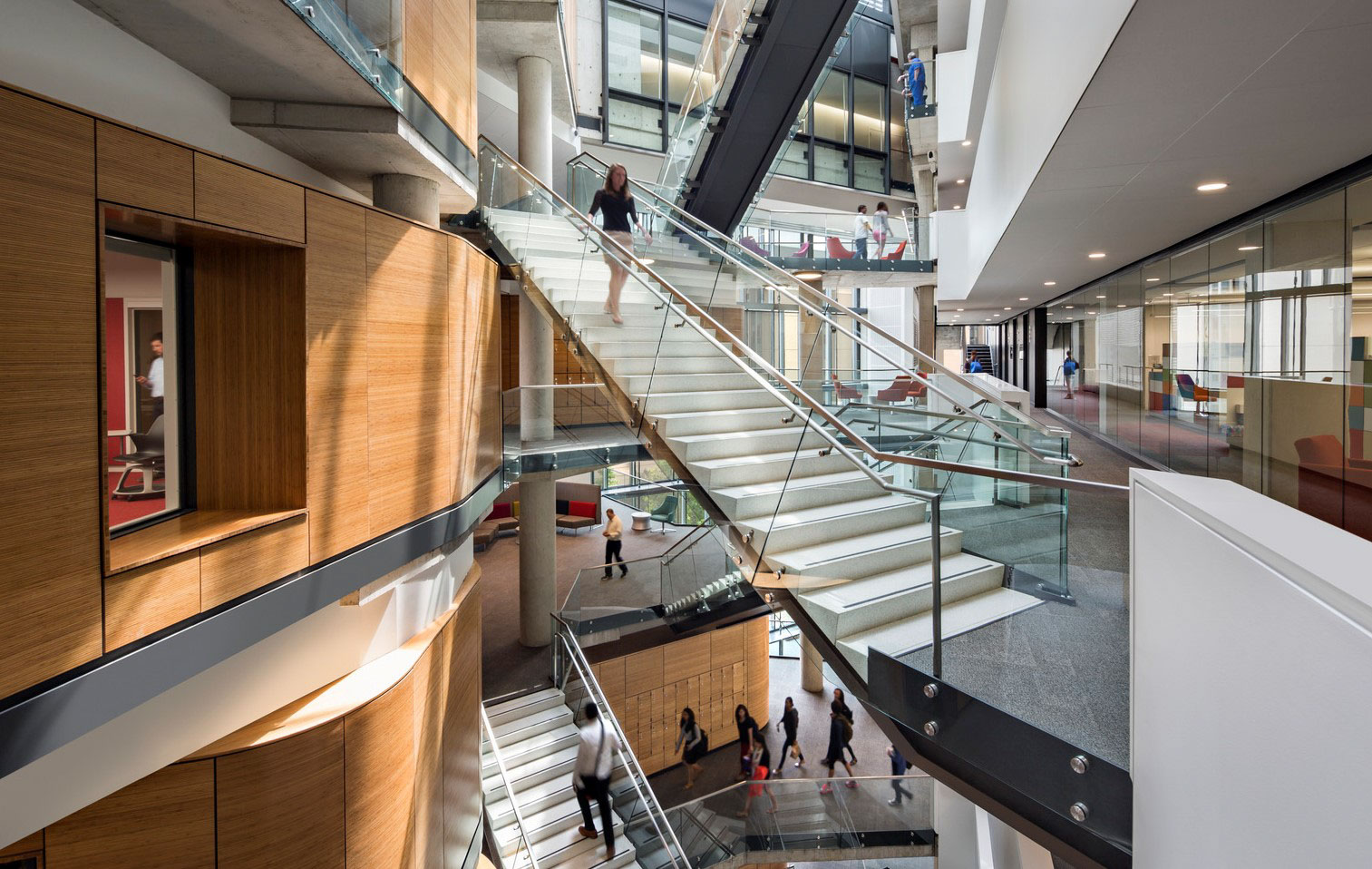 A woman walks down the stairs at Milken School of Public Health