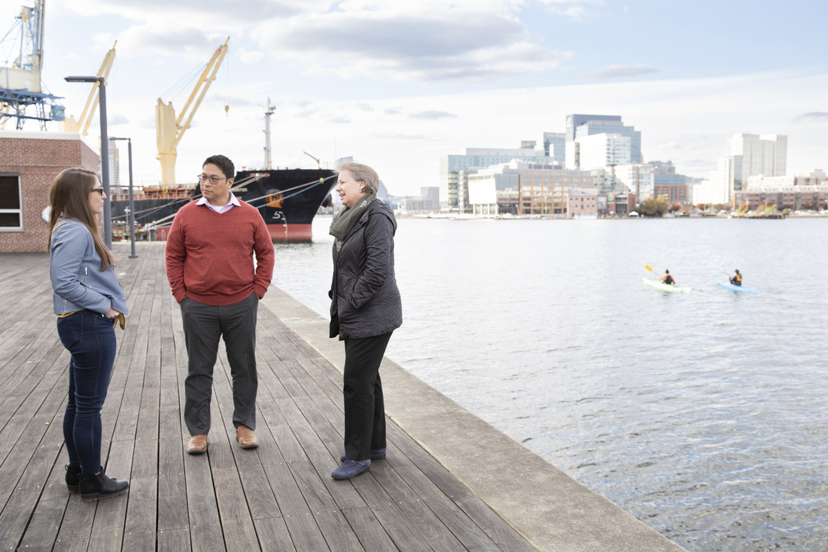 Three employees talk outside of the Baltimore office.