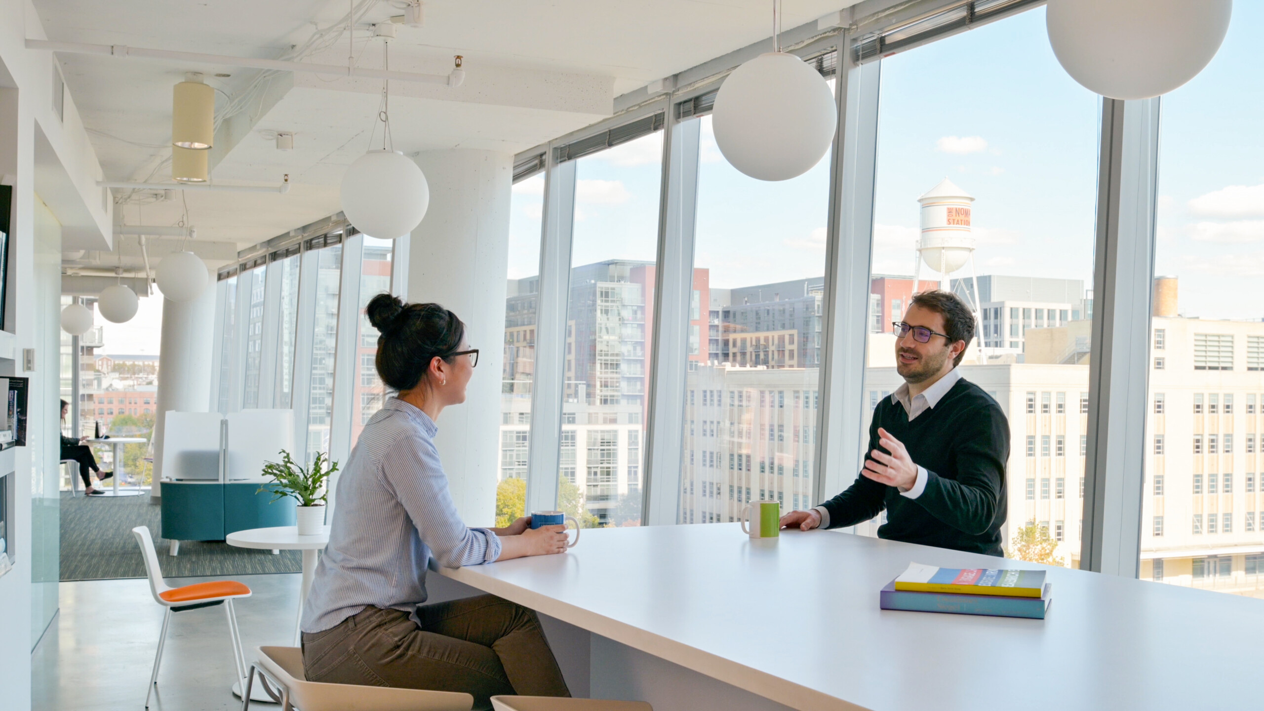 Employees talk around a table at the D.C. Ayers Saint Gross office.