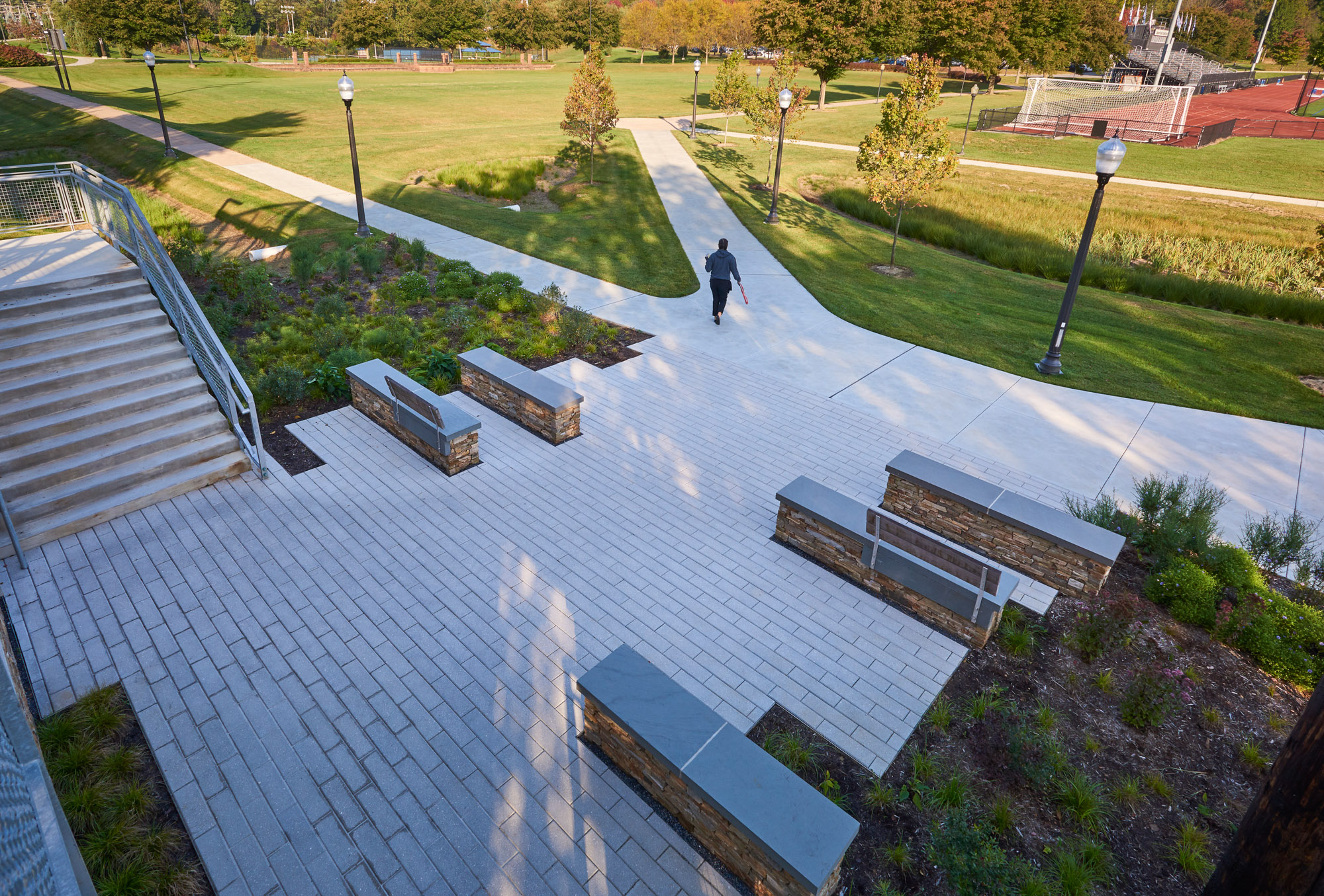 The north courtyard of the Lebanon Valley College pedestrian bridge, featuring stone benches and...