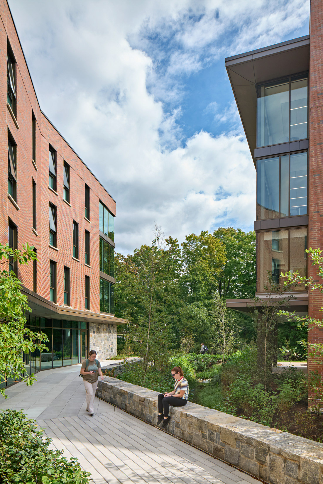Students walking through a landscaped plaza at Quinnipiac University's The Grove