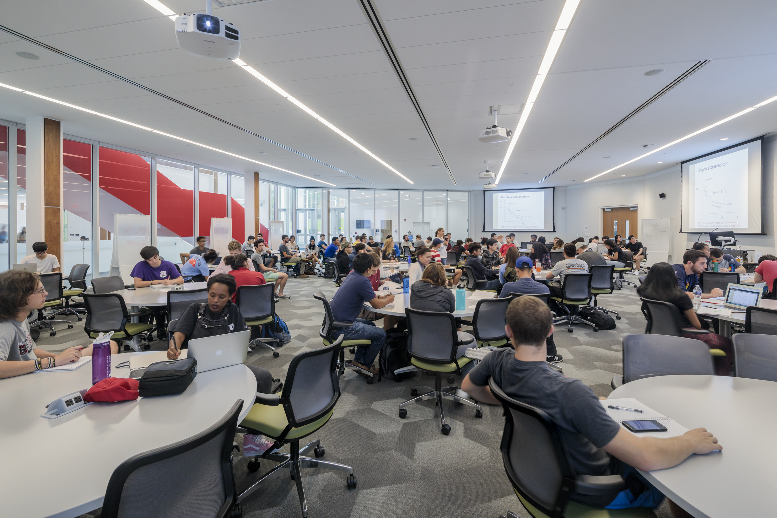 A large flexible classroom with moveable chairs and tables and windows