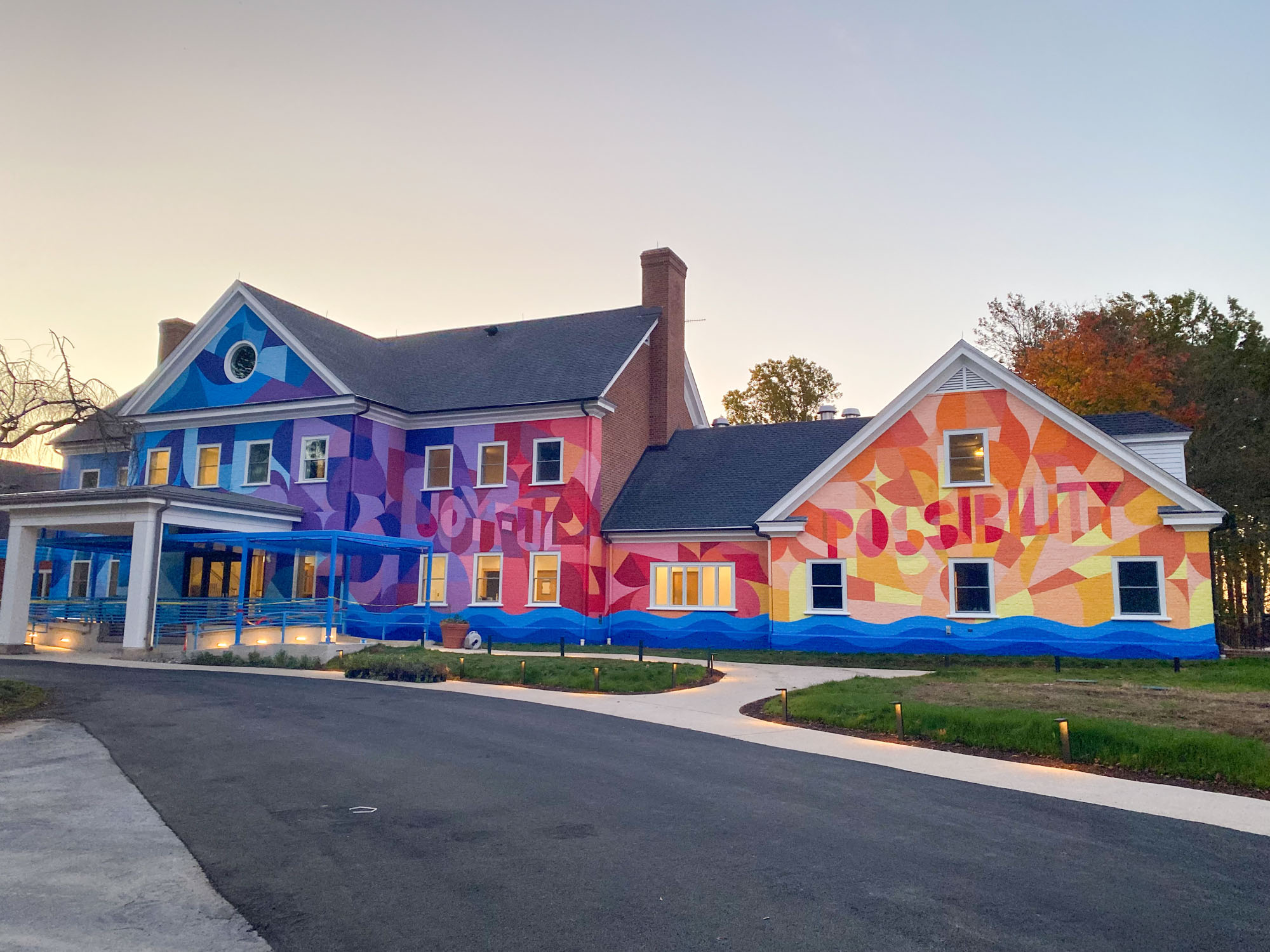 The River House at Hole in the Wall Gang Camp with a colorful mural and blue awning