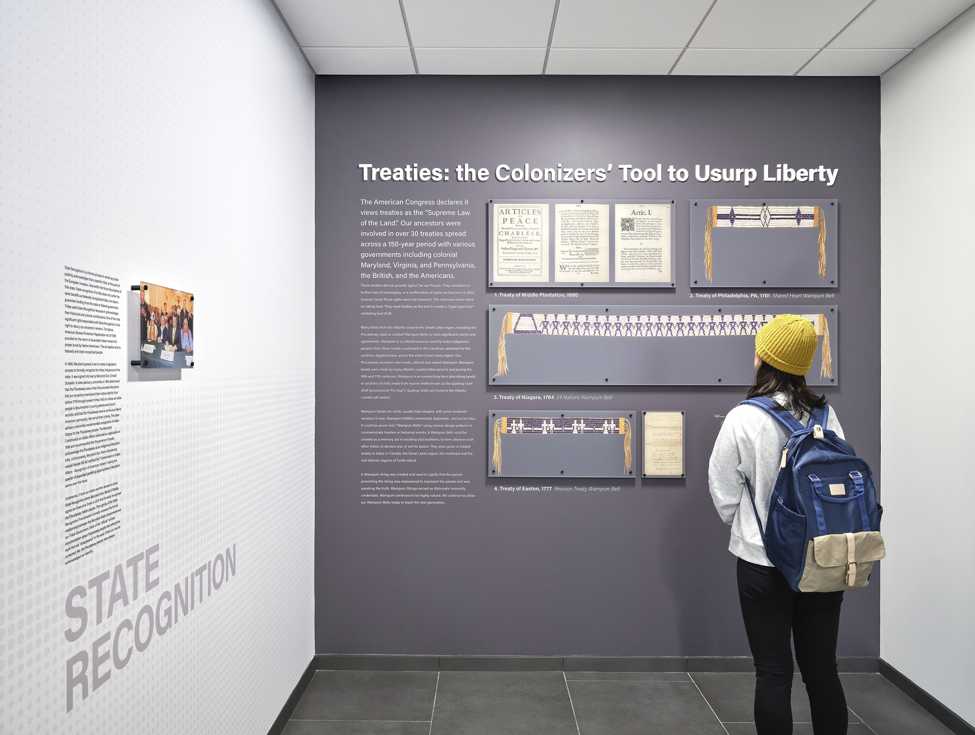 A student observes an exhibit wall honoring the history of the Piscataway tribe.