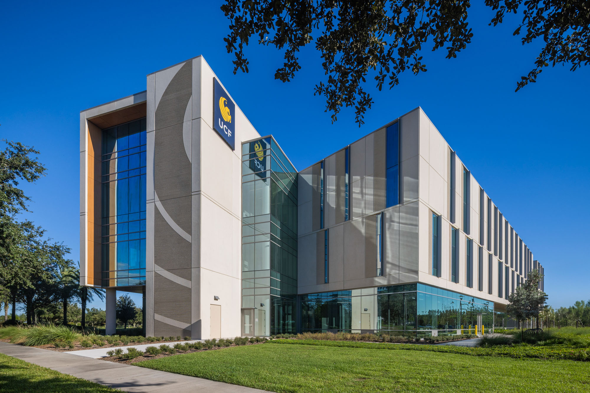 Exterior corner view of the UCF Dr. Phillips Nursing Pavilion, featuring a modern facade with glass...