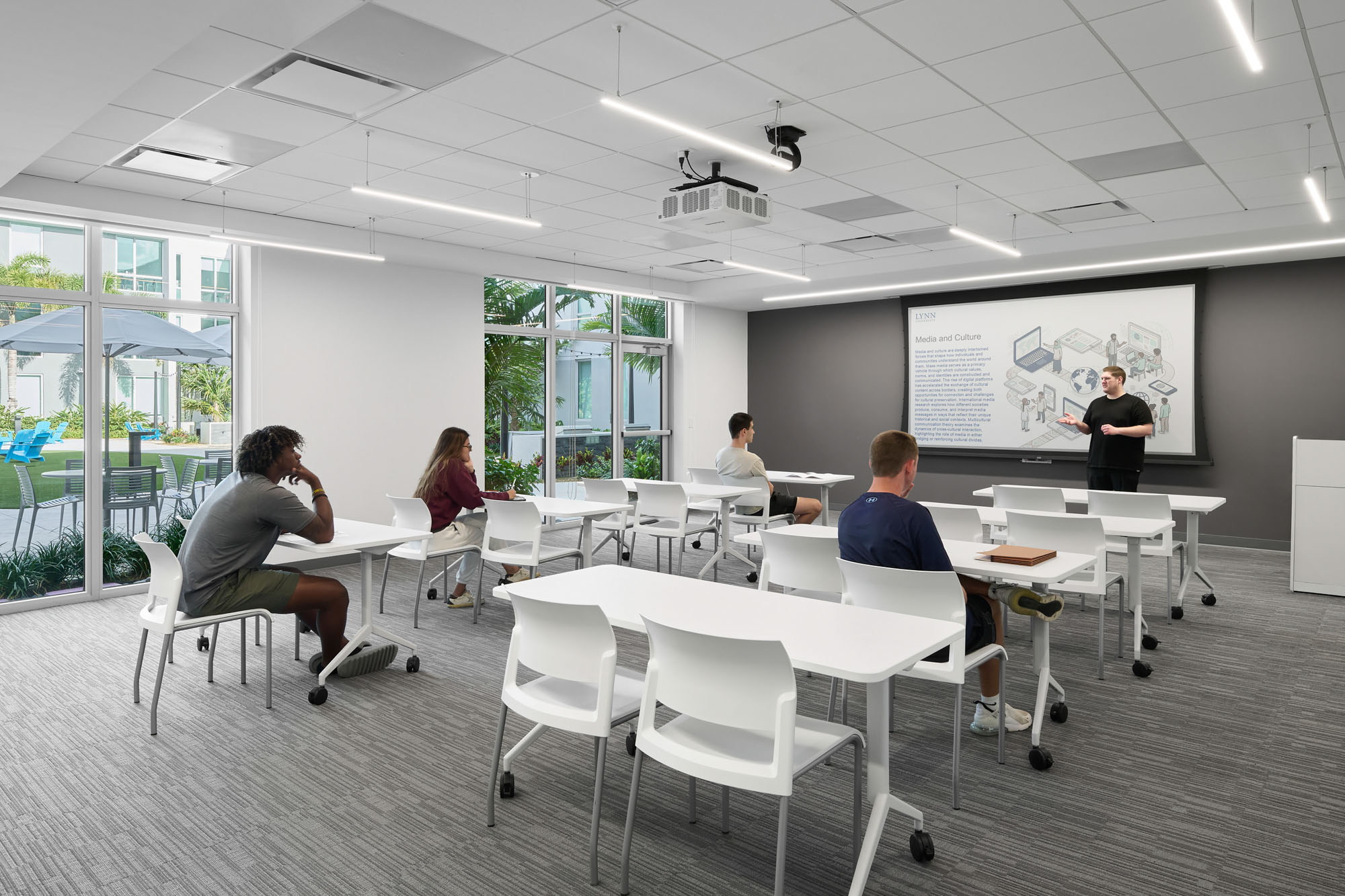 Interior view of a flexible classroom within Banyan Residence Hall. The room features white rectangular...