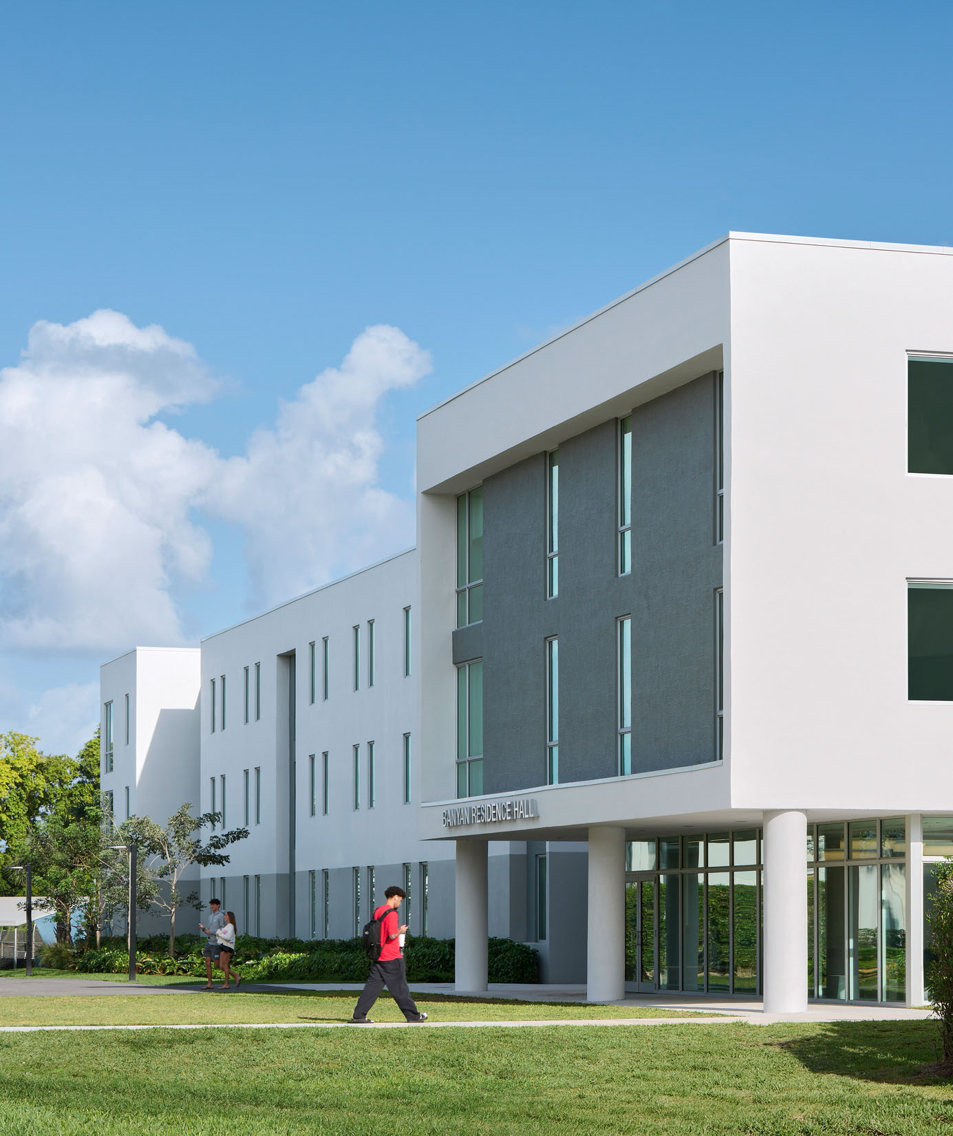 A person walks toward the entrance of Banyan Residence Hall at Lynn University